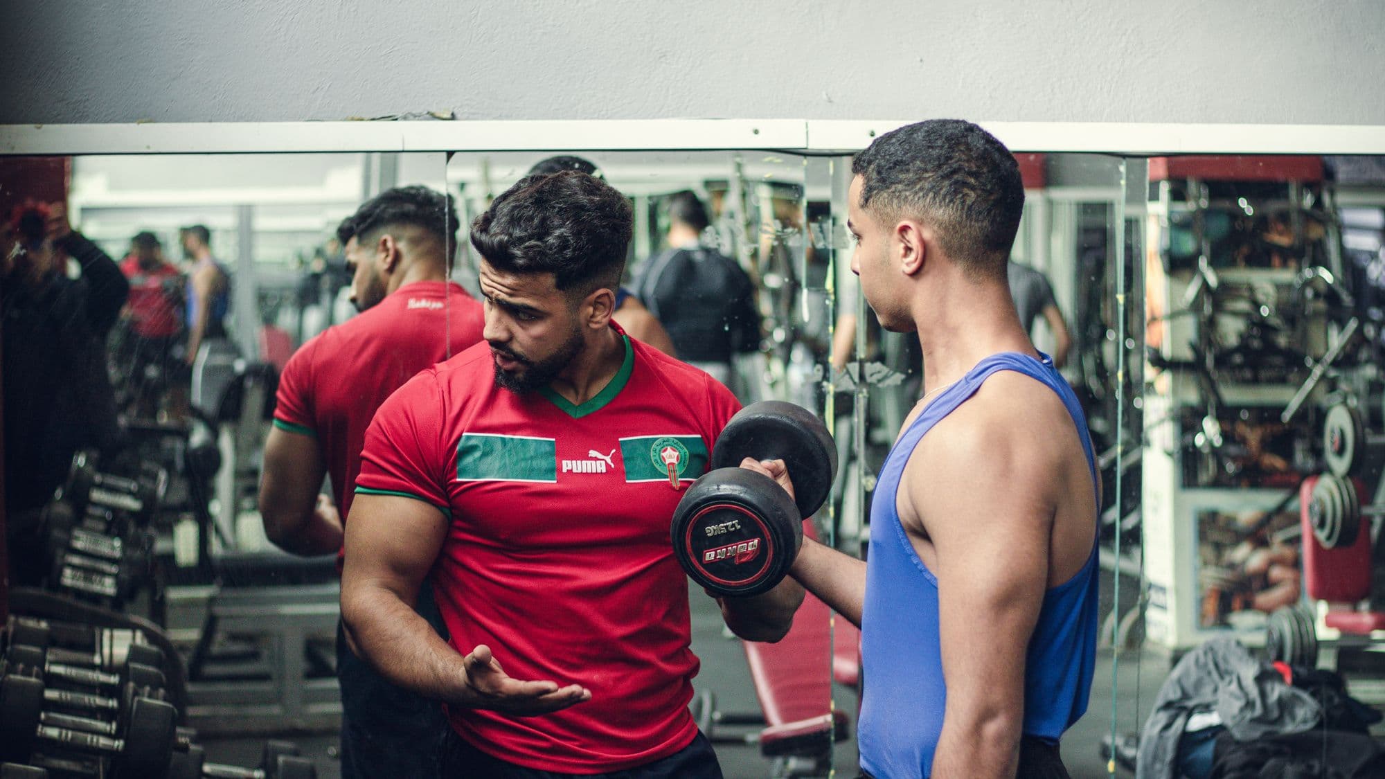 A trainer coaching a client through a weights session
