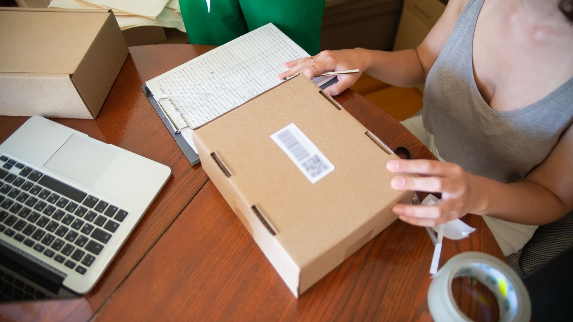 Two people packing online orders into boxes in a small business workspace