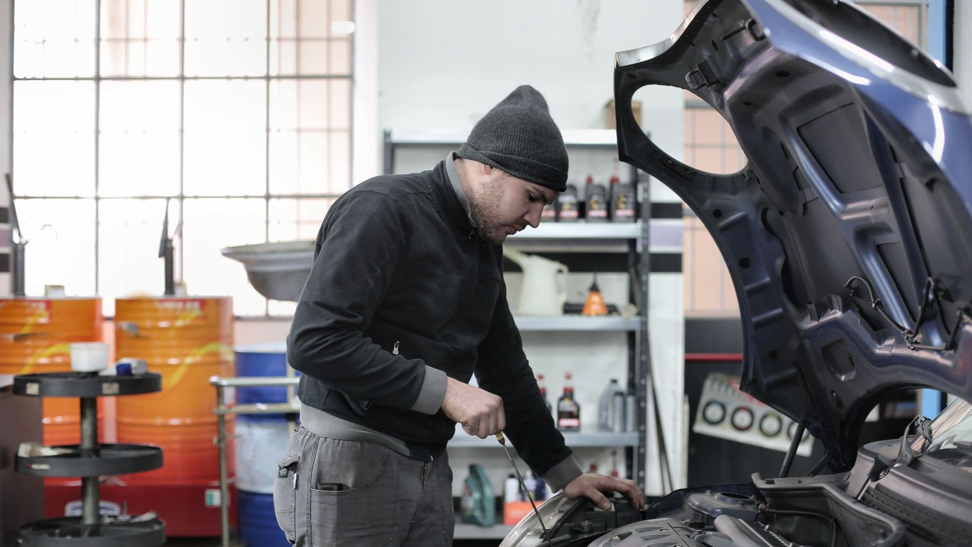 A mechanic working on an engine in a workshop bay