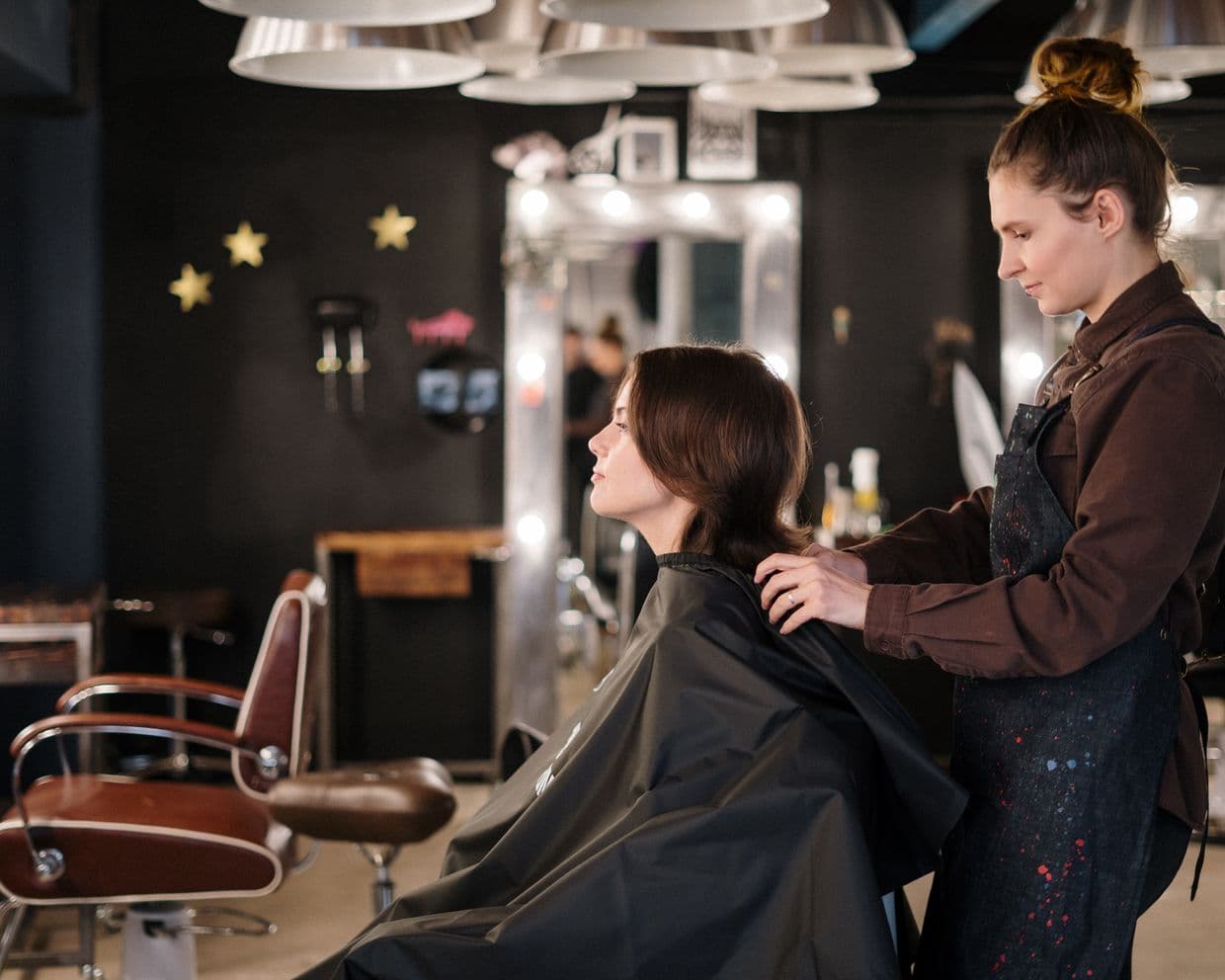 A stylist finishing a client's hair in a salon