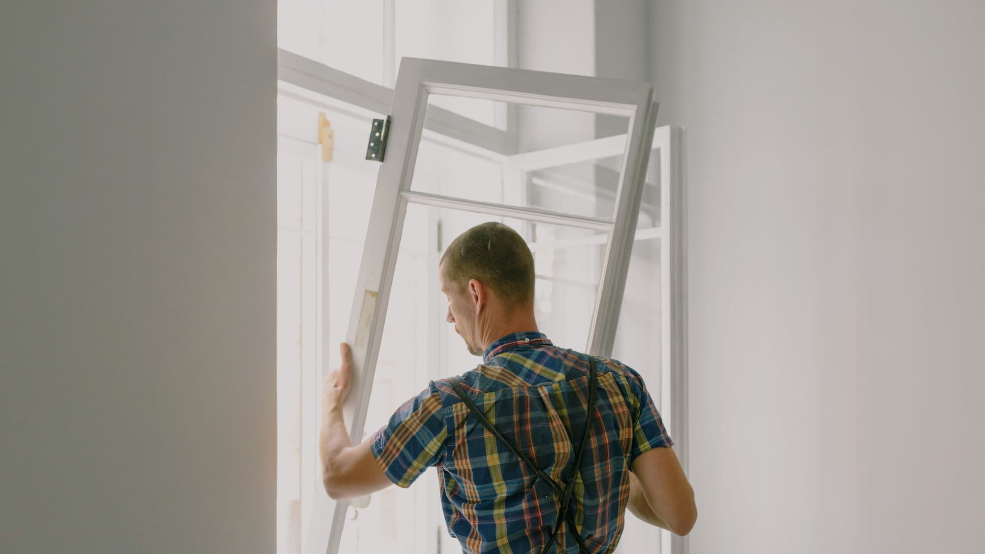A fitter mounting a new window frame during a renovation