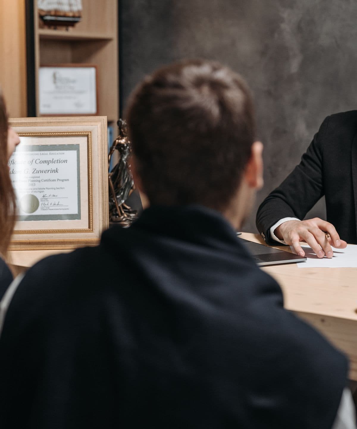 A solicitor going through documents with two clients across a desk