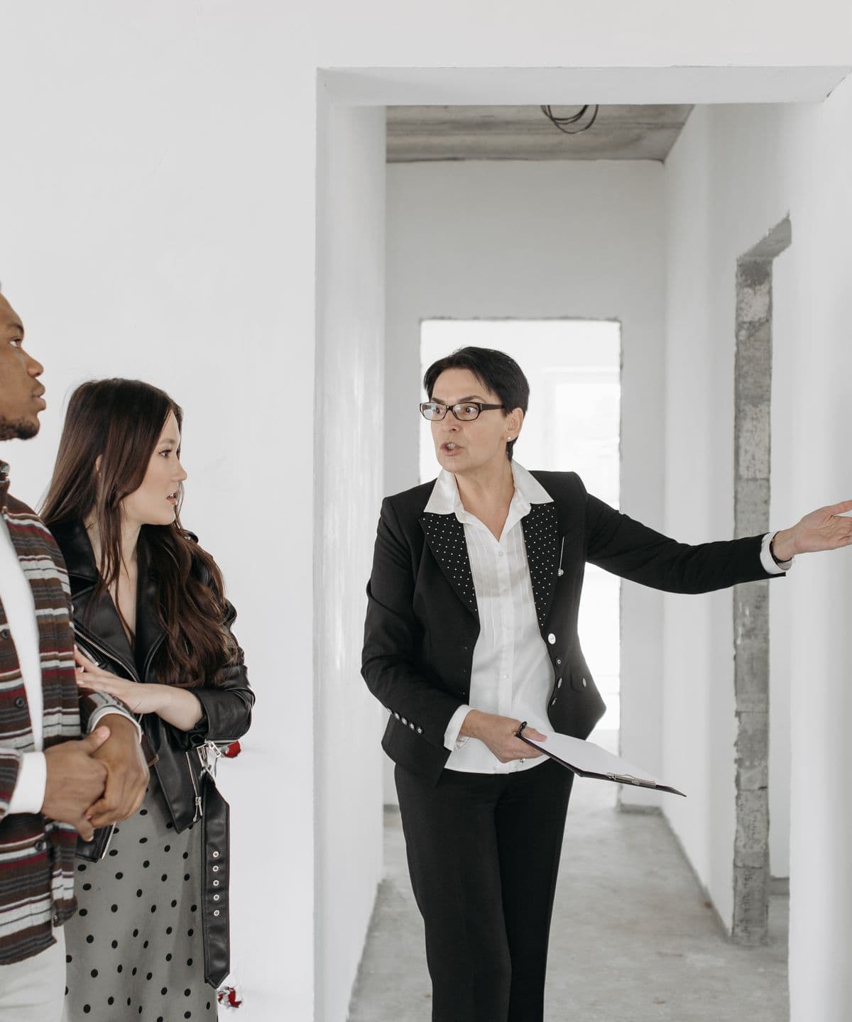 An agent showing a couple around an unfinished property