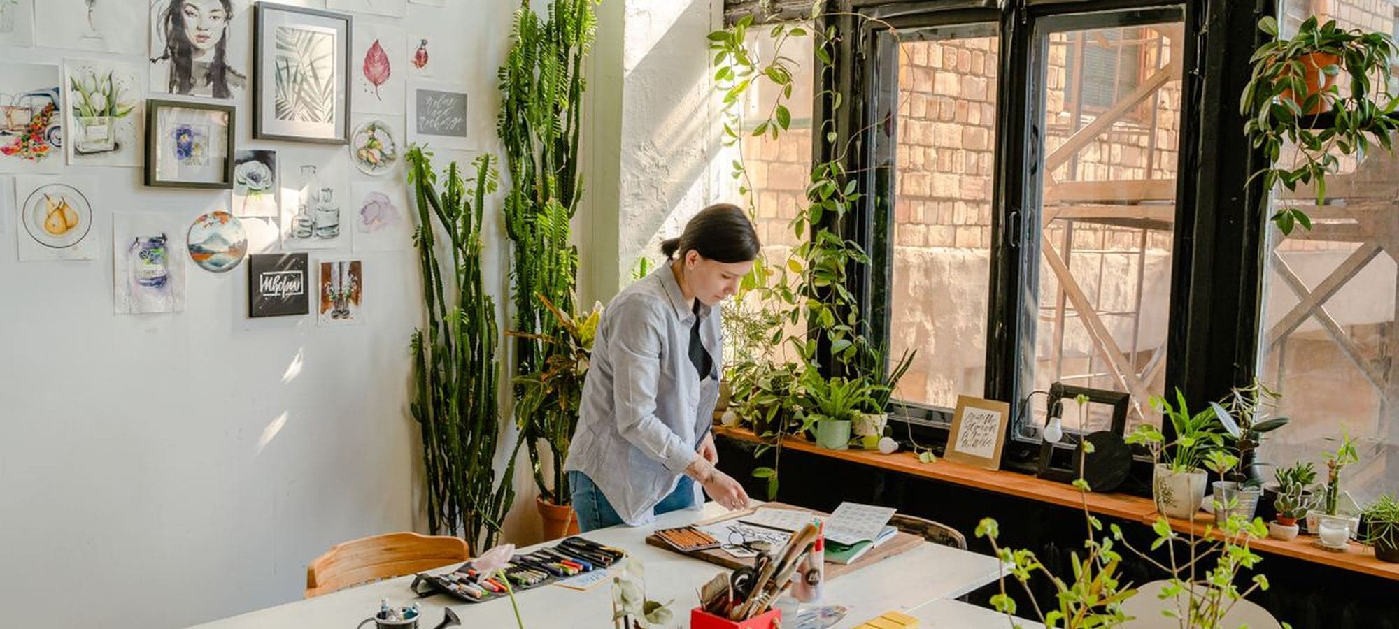A workbench in a bright studio surrounded by plants