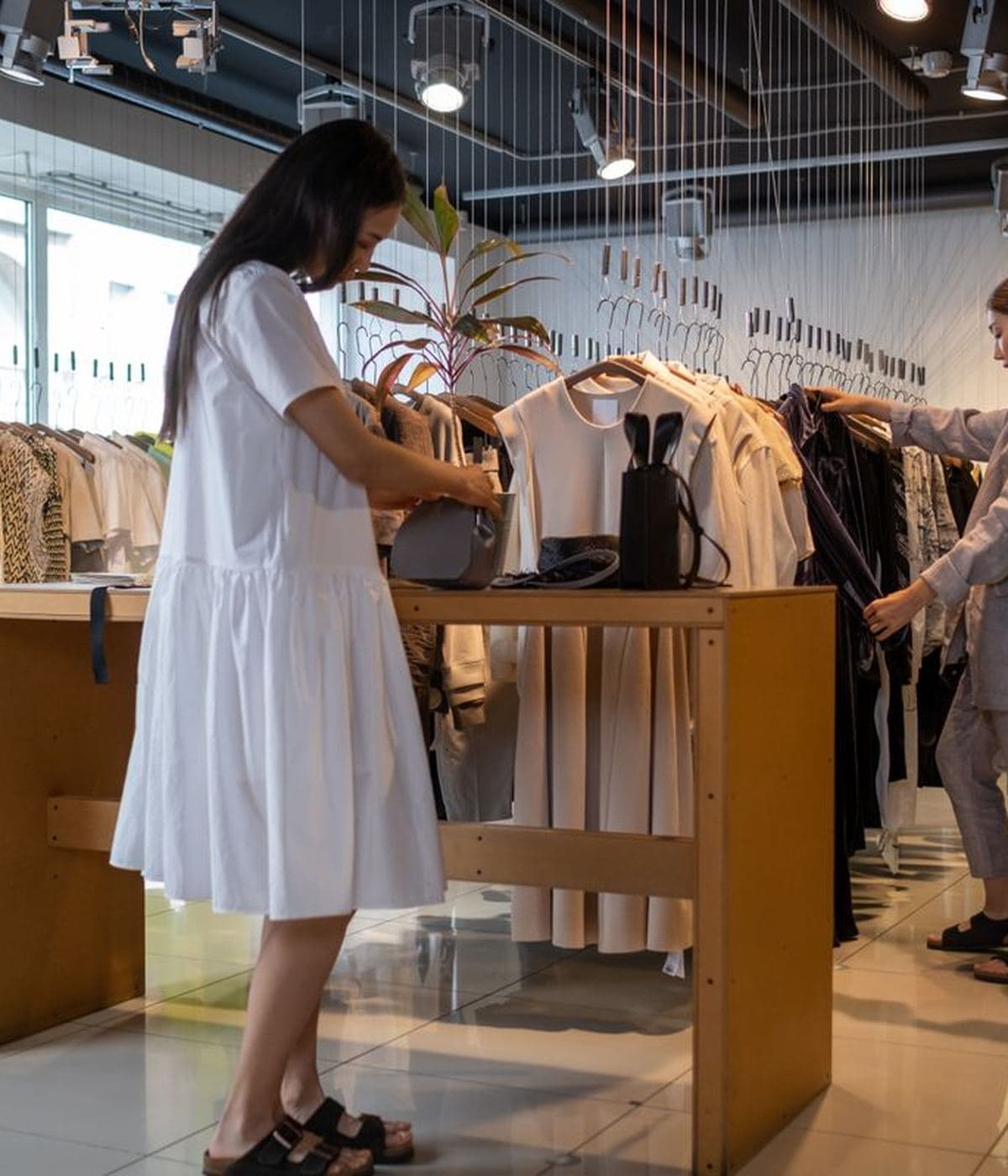 Staff arranging stock in a bright clothing shop