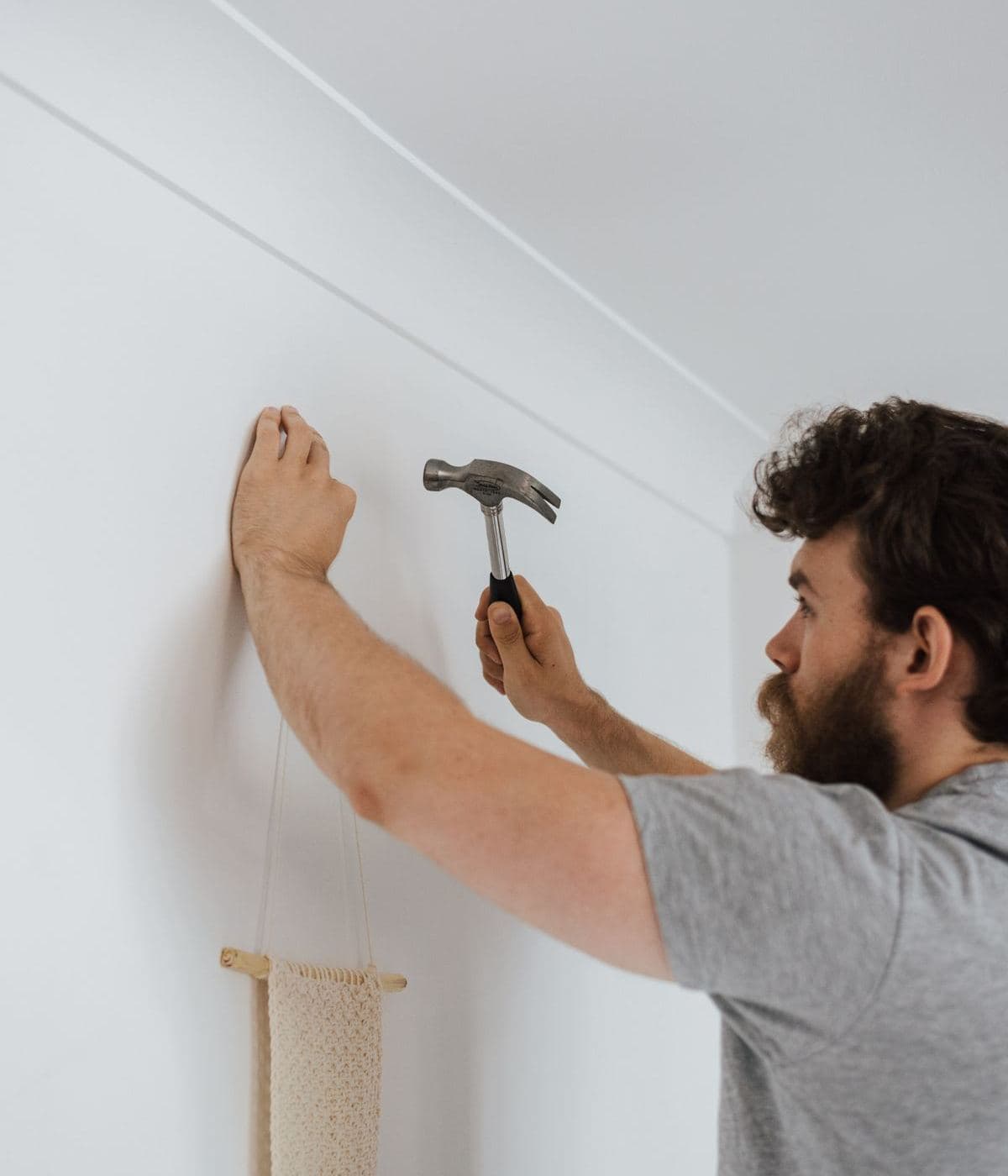 Two people fitting a fixture to a wall in a bright room