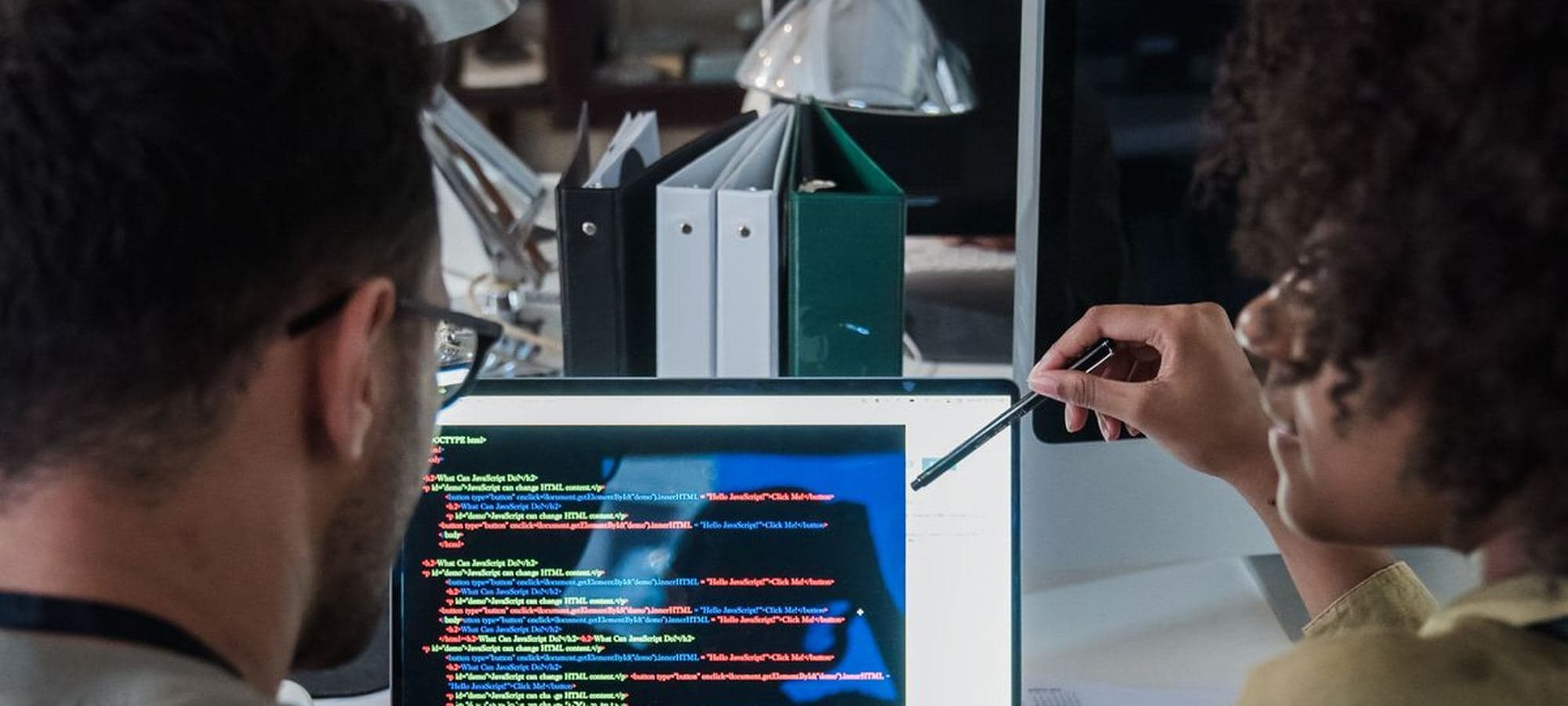 Two colleagues working through a design at a desk in a bright office